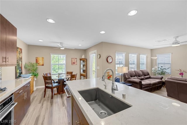 kitchen with appliances with stainless steel finishes, a sink, light wood-style flooring, a ceiling fan, and recessed lighting