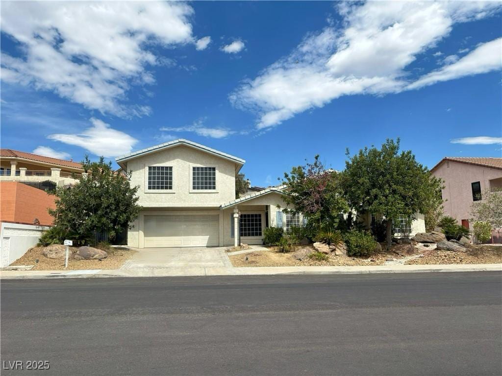 view of front facade featuring stucco siding, driveway, and a garage