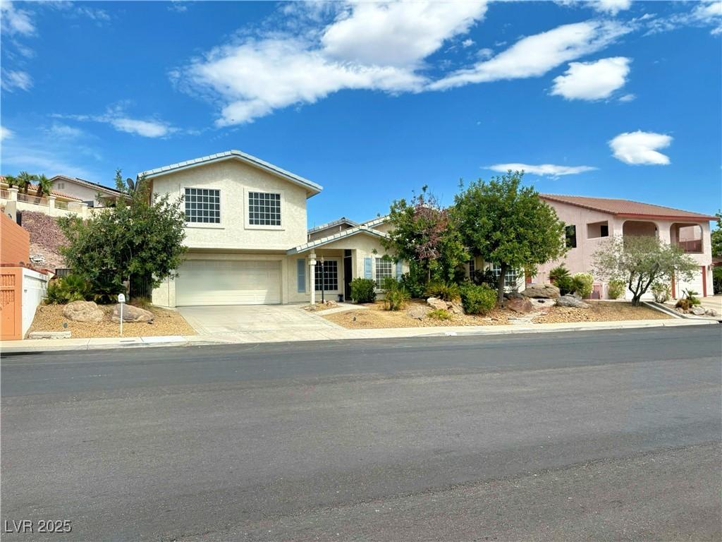 obstructed view of property featuring a garage, stucco siding, and driveway