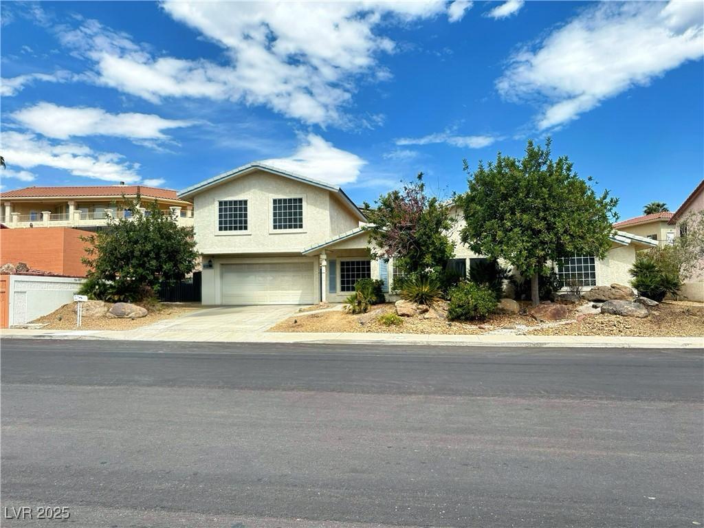 view of front of home with stucco siding, driveway, and a garage