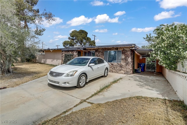 view of front of property with driveway and stone siding