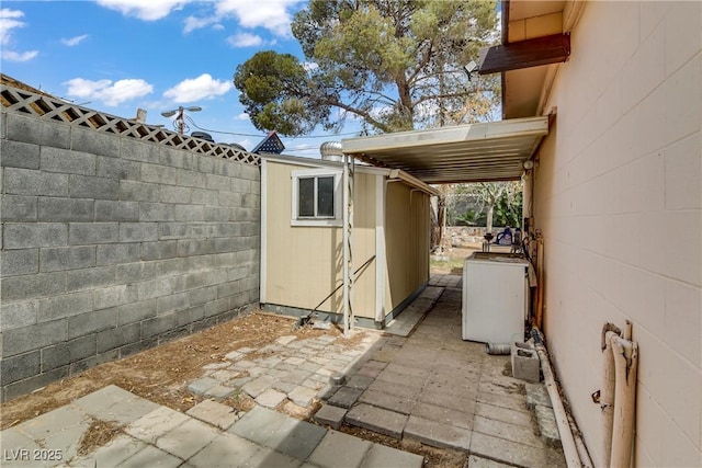 exterior space with an outdoor structure, fence, and a storage shed