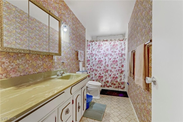 bathroom with vanity, wallpapered walls, and toilet