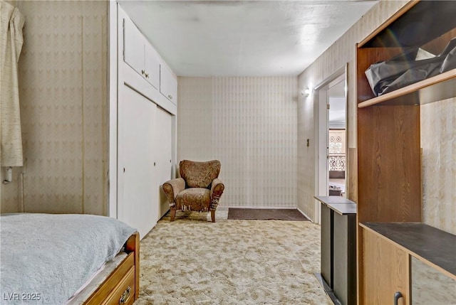 carpeted bedroom with a closet and wallpapered walls