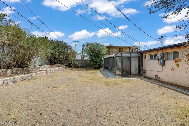 view of yard featuring a sunroom and a fenced backyard