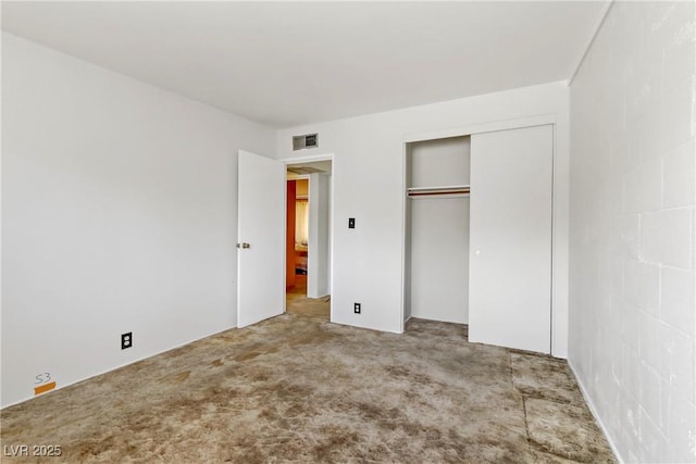 unfurnished bedroom featuring visible vents, carpet, and a closet