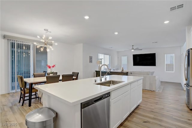 4436 Mural Glen Ct, North Las Vegas, NV 89084 - kitchen with appliances with stainless steel finishes, light wood-style flooring, white cabinetry, a center island with sink, and a chandelier