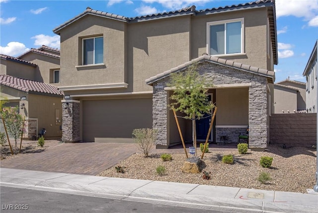 4436 Mural Glen Ct, North Las Vegas, NV 89084 - view of front of house with fence, stone siding, a garage, stucco siding, and decorative driveway