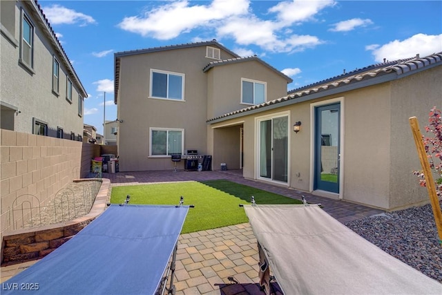4436 Mural Glen Ct, North Las Vegas, NV 89084 - rear view of property featuring fence, a patio, stucco siding, a tiled roof, and a lawn