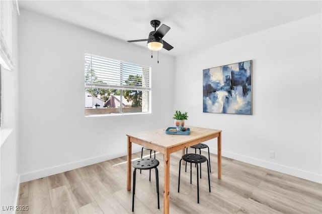 dining room featuring baseboards, light wood-style floors, and a ceiling fan