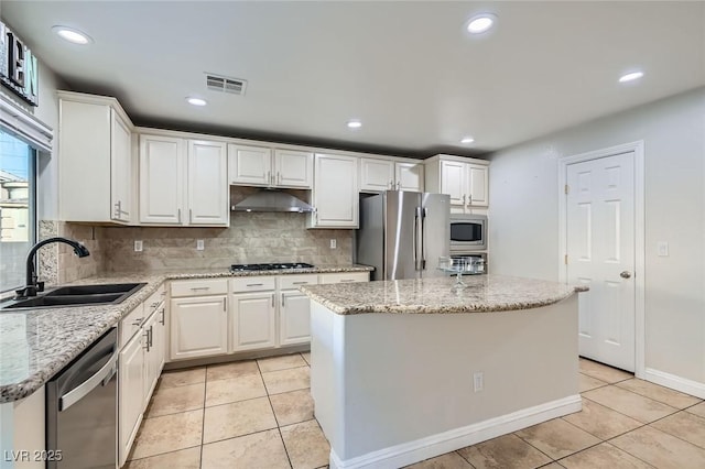 kitchen with a sink, stainless steel appliances, white cabinetry, under cabinet range hood, and visible vents