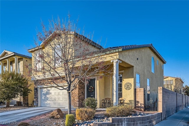 view of front facade featuring an attached garage, fence, driveway, and stucco siding