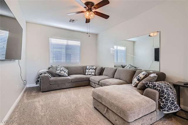carpeted living room with baseboards, a wealth of natural light, a ceiling fan, and visible vents