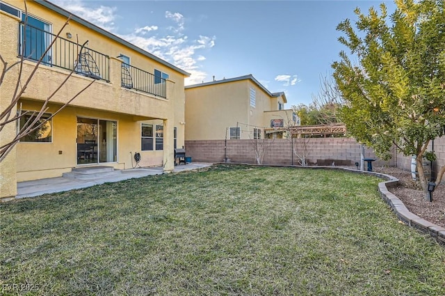 view of yard featuring a fenced backyard, a patio, and a balcony