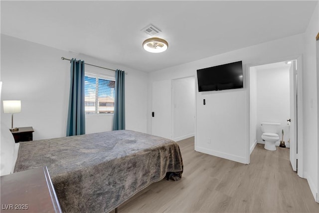 bedroom featuring visible vents, light wood-style flooring, ensuite bathroom, and baseboards