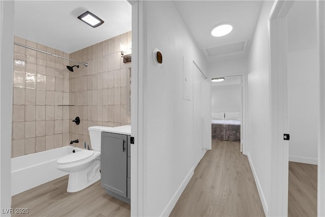 bathroom featuring vanity, wood finished floors, toilet, and shower / washtub combination