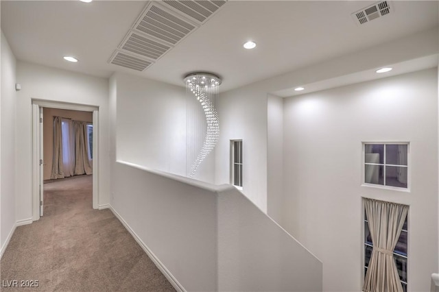 hallway featuring carpet floors, baseboards, recessed lighting, and visible vents