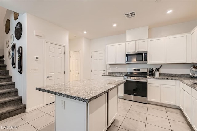 489 Filaree Pl, Henderson, NV 89015 - kitchen featuring visible vents, appliances with stainless steel finishes, a center island, light tile patterned floors, and white cabinetry