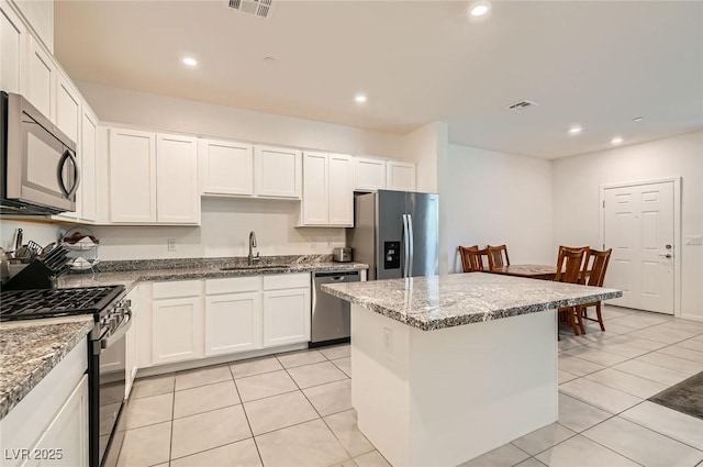 489 Filaree Pl, Henderson, NV 89015 - kitchen with a sink, white cabinets, a kitchen island, and stainless steel appliances