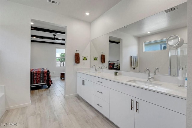 ensuite bathroom featuring visible vents, a sink, ceiling fan, and ensuite bath