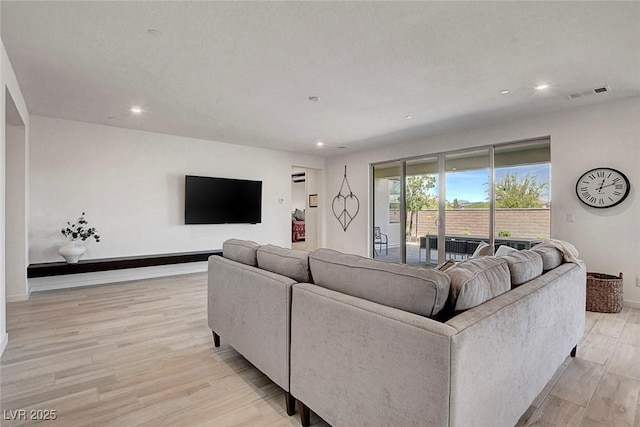living room featuring light wood-style floors, recessed lighting, and visible vents