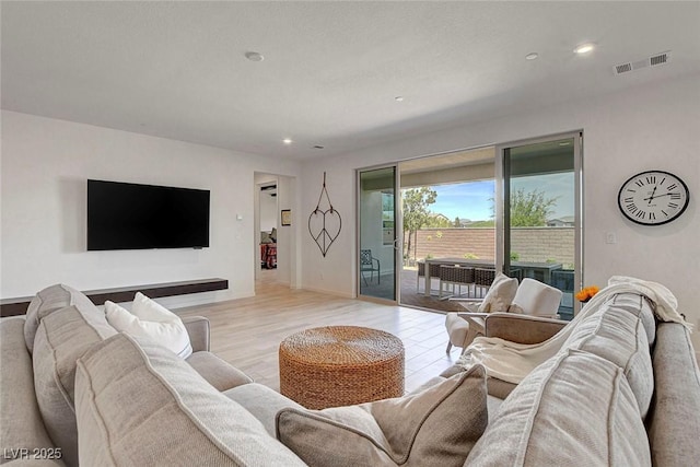 living room featuring visible vents, recessed lighting, and light wood finished floors