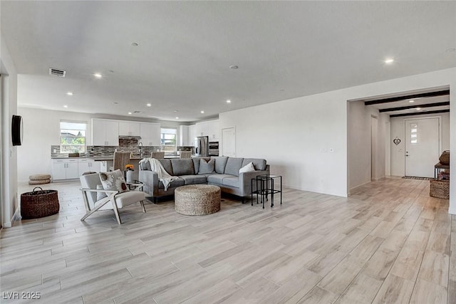 living room with recessed lighting, light wood finished floors, and a wealth of natural light