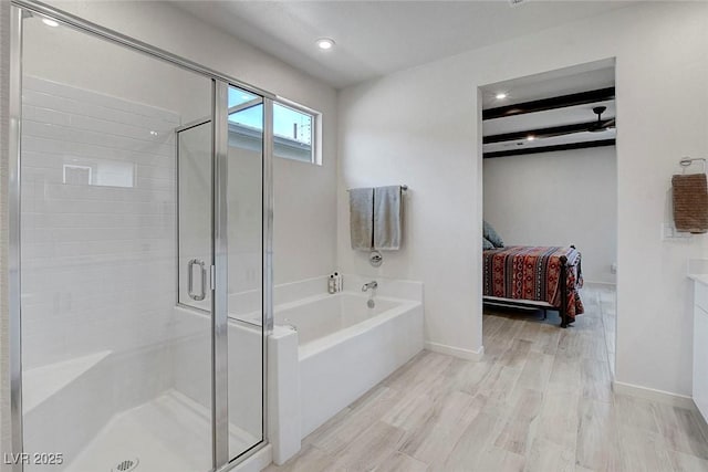 full bath featuring ensuite bath, baseboards, wood finished floors, a garden tub, and a stall shower