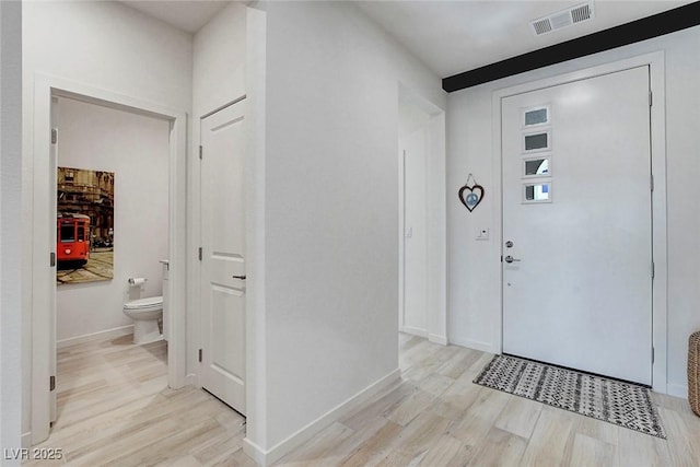 entryway featuring visible vents, light wood-style flooring, and baseboards