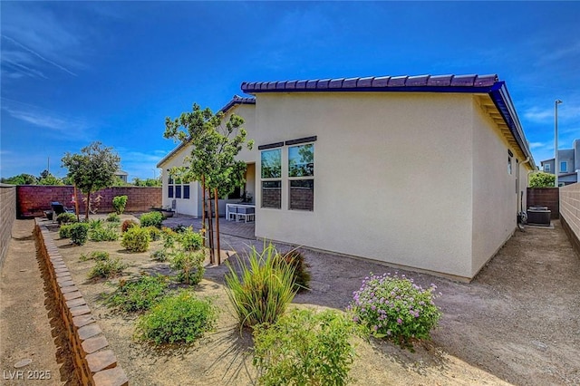 view of property exterior with a patio, a fenced backyard, stucco siding, and cooling unit