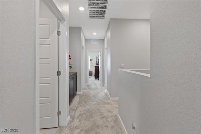 143 Aqua Commons Ln, Henderson, NV 89015 - corridor with light colored carpet, baseboards, recessed lighting, and a textured wall