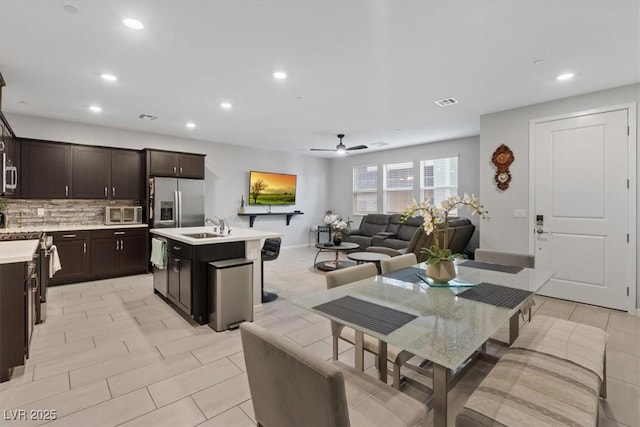 143 Aqua Commons Ln, Henderson, NV 89015 - kitchen featuring a sink, light countertops, backsplash, dark brown cabinetry, and recessed lighting