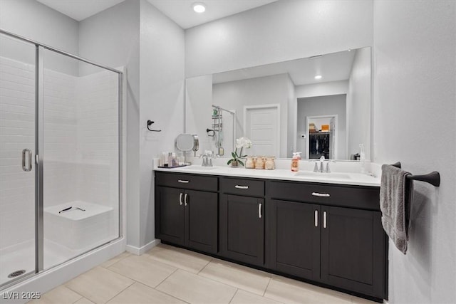 143 Aqua Commons Ln, Henderson, NV 89015 - bathroom featuring a stall shower, tile patterned floors, double vanity, a walk in closet, and baseboards