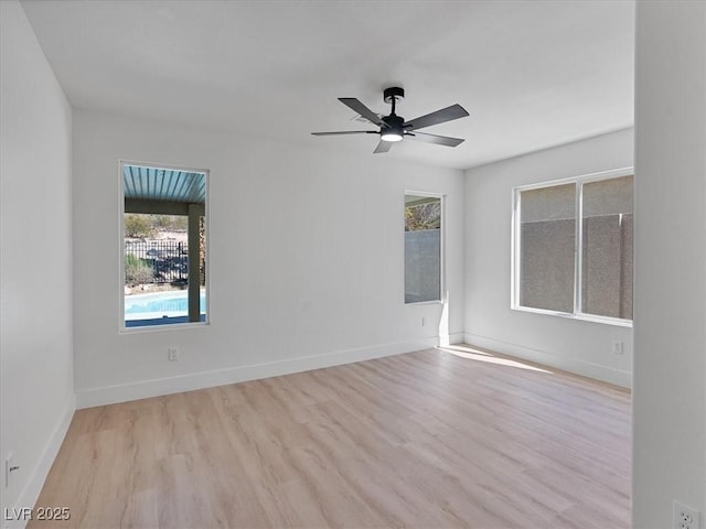 spare room with baseboards, ceiling fan, and wood finished floors