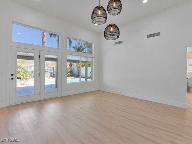 interior space with visible vents, light wood finished floors, and a high ceiling