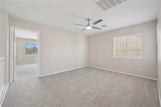 empty room featuring carpet flooring, ceiling fan, and visible vents