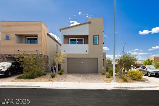 contemporary home with stucco siding, driveway, and a garage