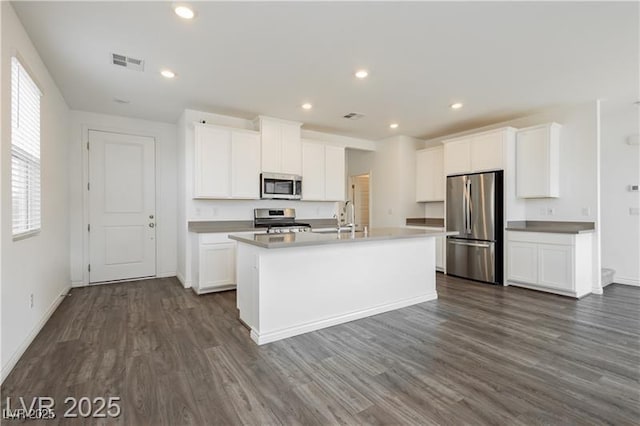 kitchen with visible vents, baseboards, dark wood-type flooring, a sink, and stainless steel appliances