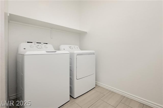 washroom with separate washer and dryer, laundry area, and baseboards