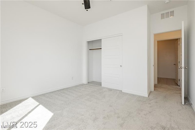 unfurnished bedroom featuring baseboards, carpet, a closet, and visible vents