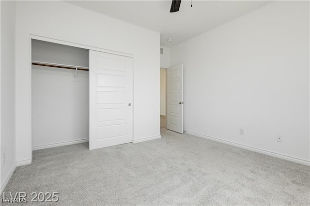 unfurnished bedroom featuring baseboards, carpet, and a closet
