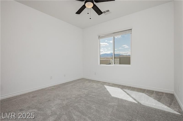 unfurnished room with visible vents, carpet, ceiling fan, and baseboards