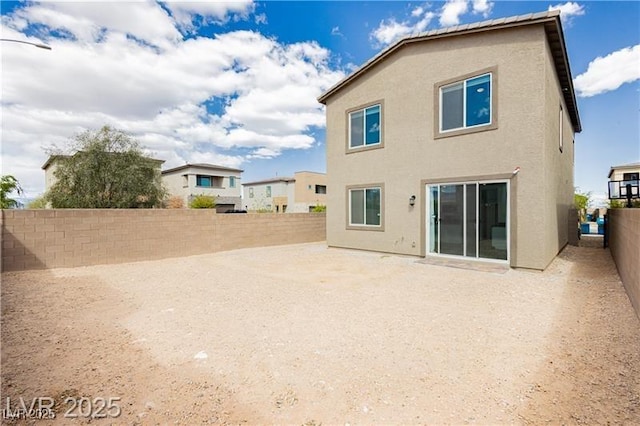 back of house featuring a patio, a fenced backyard, and stucco siding