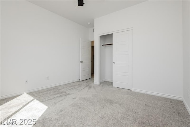 unfurnished bedroom featuring carpet floors, baseboards, ceiling fan, and a closet