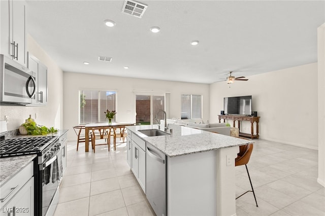 kitchen featuring visible vents, a sink, ceiling fan, and stainless steel appliances