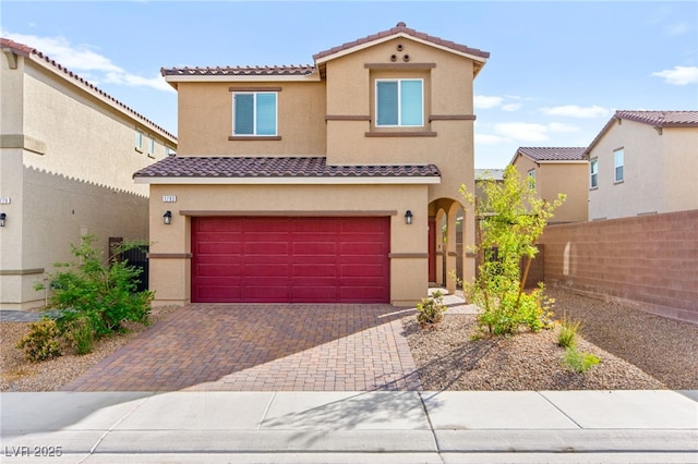 mediterranean / spanish-style home featuring a garage, stucco siding, a tile roof, and fence