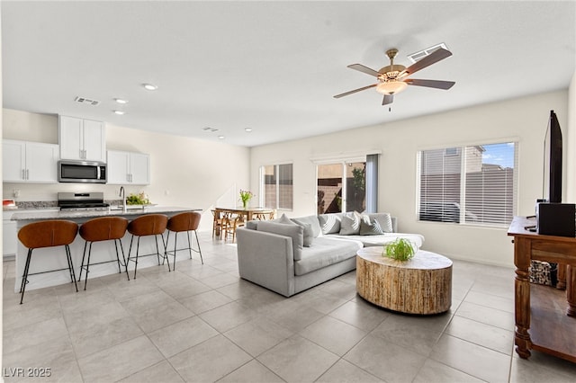 living area featuring light tile patterned floors, ceiling fan, recessed lighting, and visible vents