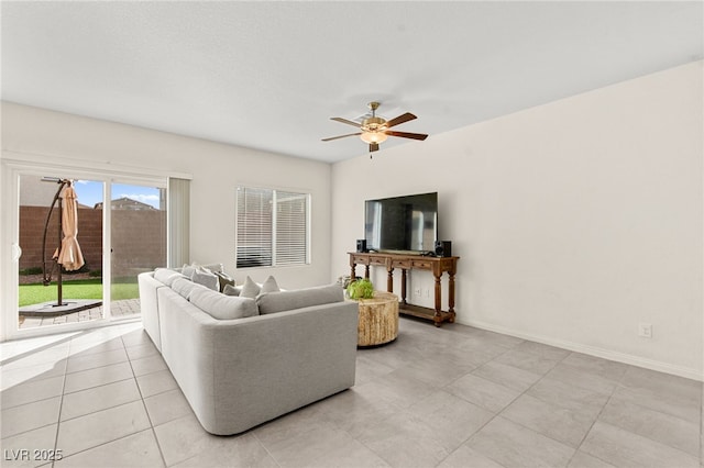 living room featuring baseboards, a ceiling fan, and light tile patterned floors