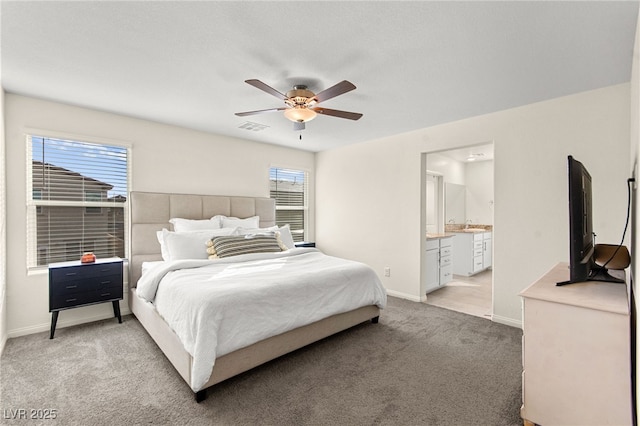 bedroom with visible vents, light carpet, baseboards, connected bathroom, and a ceiling fan