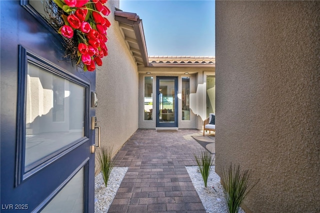 11954 Camden Ridge Ct, Las Vegas, NV 89138 - view of exterior entry with stucco siding, a patio area, and a tiled roof
